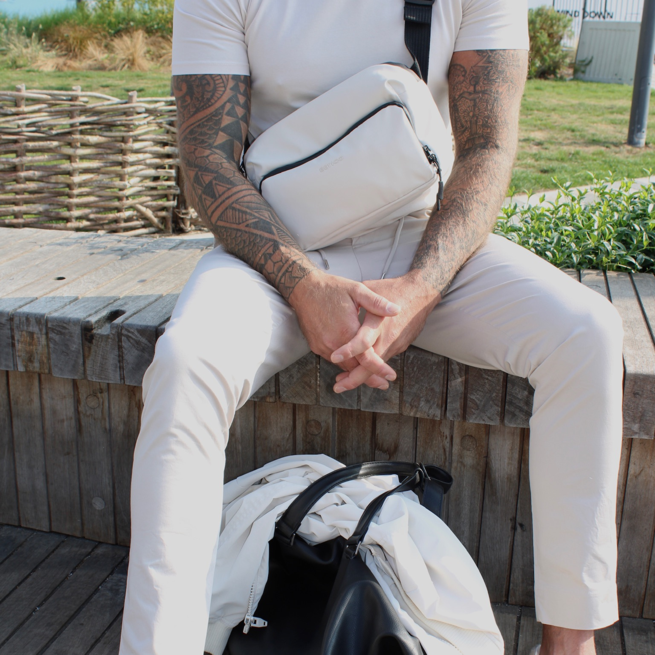Man wearing the cream Betico Essential crossbody organiser bag outdoors for discreet everyday travel, wellness organisation and daily essentials carry
