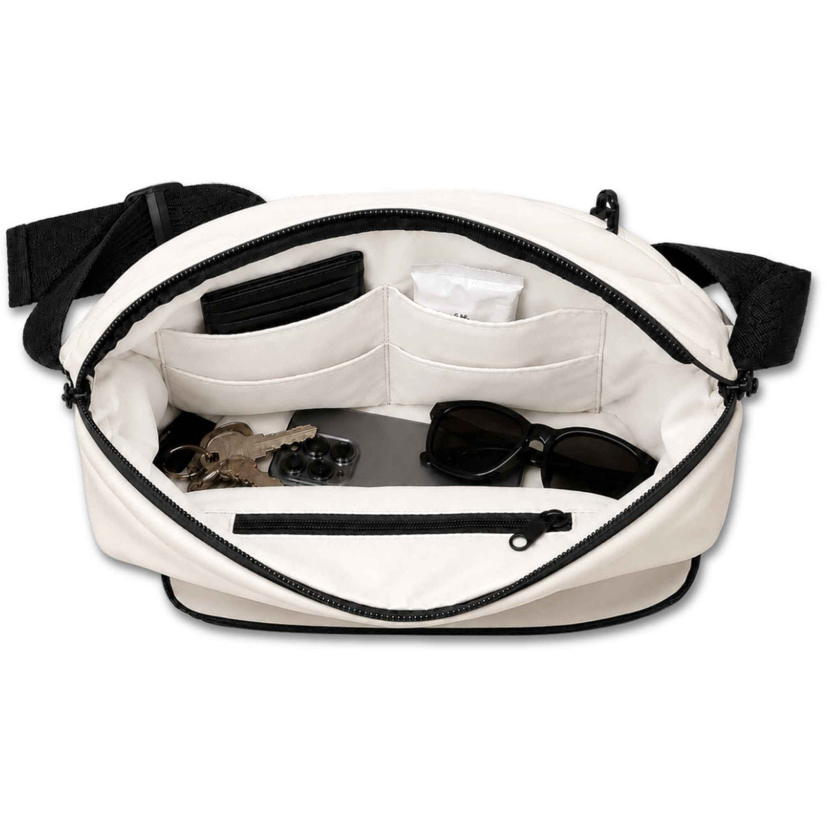 Cream and black Betico Essential Diabetes Bag with the main compartment open, showing four slip pockets, an internal zip pocket, phone, keys, wallet and sunglasses.