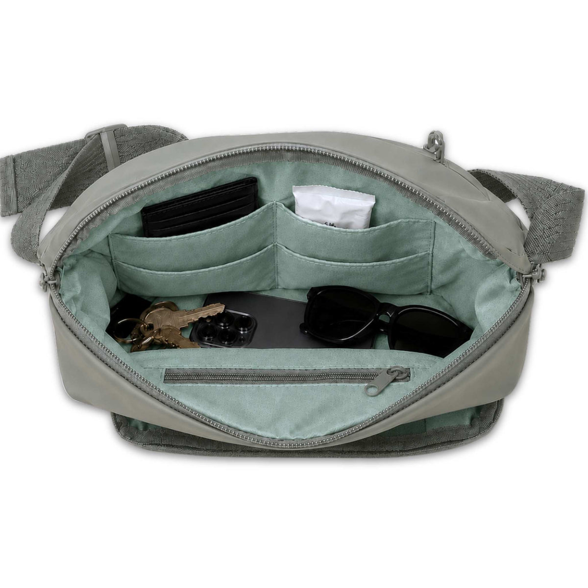 Green Betico Essential Diabetes Bag with the main compartment open, showing four slip pockets, an internal zip pocket, phone, keys, wallet and sunglasses.