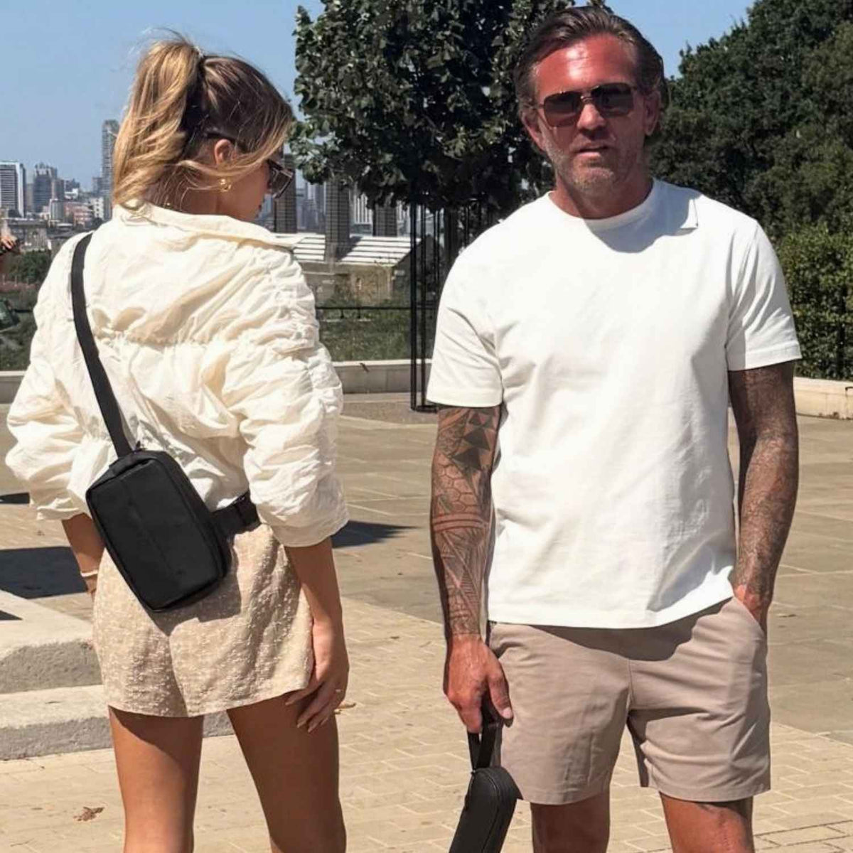 Black Betico Compact Crossbody Bag worn outdoors in a founder story lifestyle image, showing discreet hands-free everyday carry in a city setting