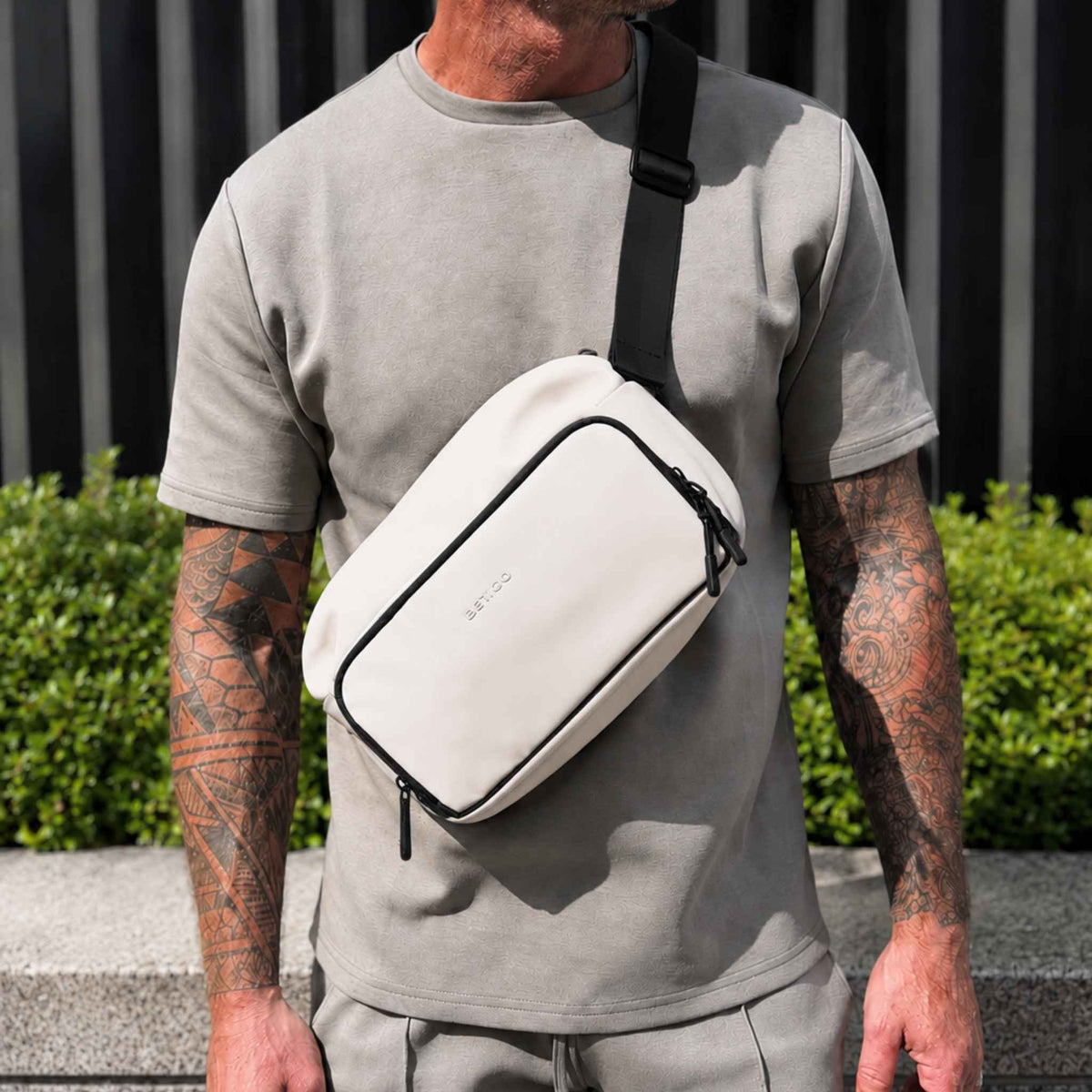 Man wearing the cream and black Betico Essential Diabetes Bag crossbody outdoors, showing its adjustable strap and everyday fit.
